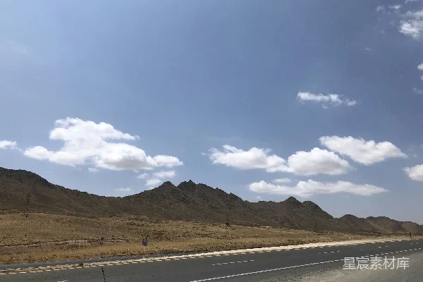 高清摄影 灰色的混凝土路面在白天的蓝天白云下俯瞰着山脉。
