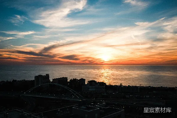 高清摄影 夕阳正悬挂在海边的城市上空。