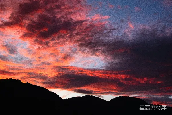 高清摄影 鲜艳的红色和橙色夕阳云层在黑暗的山影上。