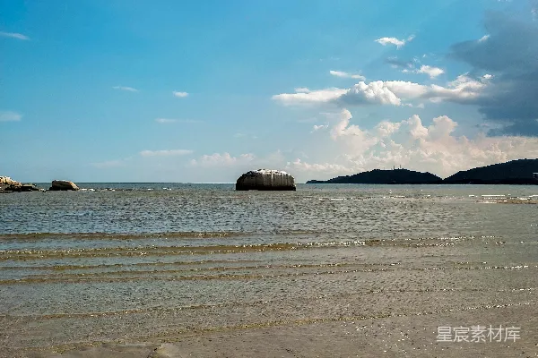 高清摄影 一个有沙子的海滩，背景中有一片水域。