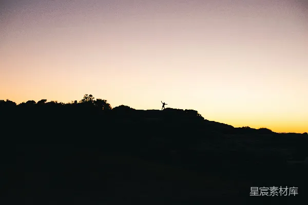 高清摄影 一个人站在山顶上，夕阳西下。