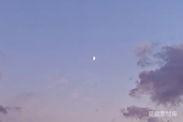 高清摄影 在柔和天空中的一弯新月，伴随着轻柔的云彩。