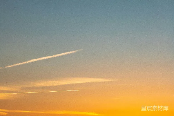 高清摄影 城市天际线上方绚丽的夕阳天空，空中有航迹。
