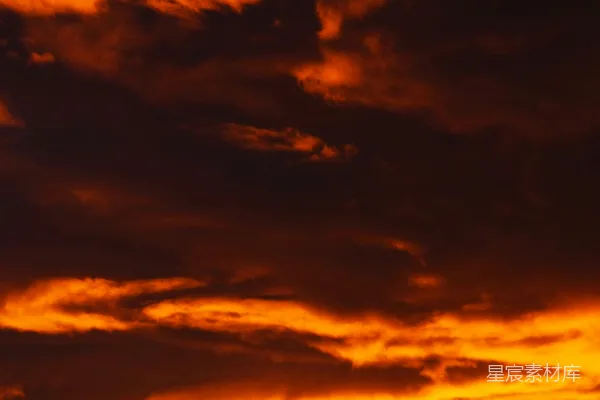 高清摄影 夕阳下，天空被戏剧性的橙色和红色云朵填满。