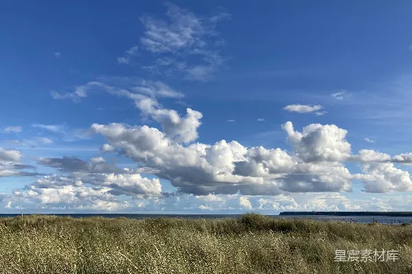 高清摄影 一片草地，天空中有云彩。