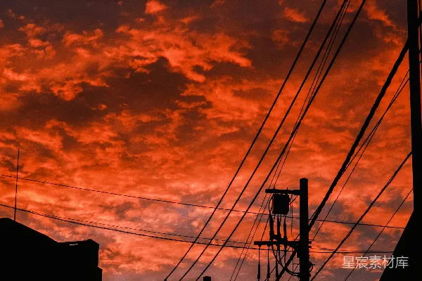 高清摄影 夕阳映红的天空下，剪影般的建筑物和输电线。