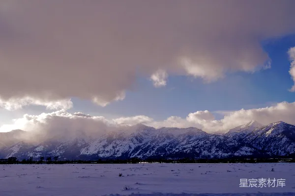 高清摄影 白天多云的天空下覆盖着积雪的山峰