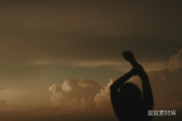 高清摄影 一个人在夕阳前举起手。