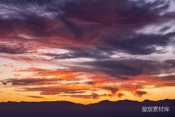 高清摄影 夕阳西下，云层和山脉在背景中。