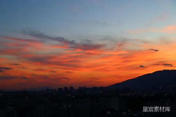 高清摄影 城市日落景色，背景中有一座山。