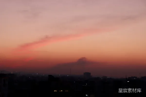 高清摄影 夕阳西下，城市上空有一片红色云彩。