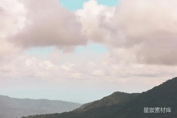 高清摄影 一座山的景色，有树木和云朵。