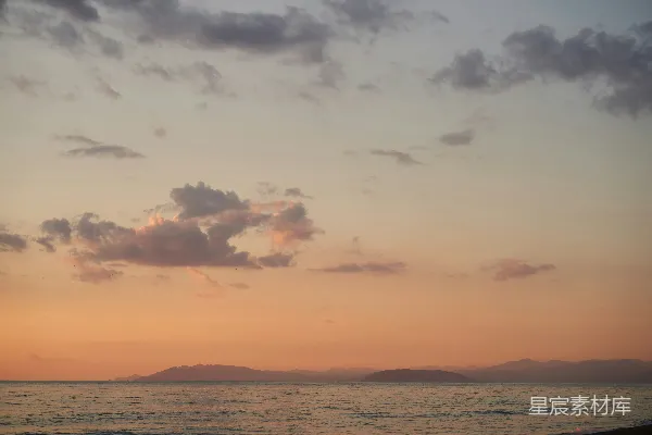 高清摄影 夕阳下的水体景色，远处是连绵的山脉。