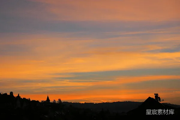高清摄影 夕阳下的山丘剪影和村庄。