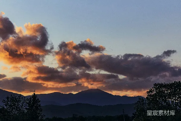 高清摄影 夕阳西下时，多云的天空下山的剪影