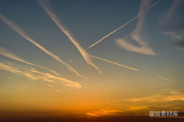 高清摄影 夕阳西下，空中有飞机的航迹云。