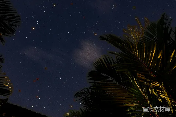 高清摄影 夜空中有星星和云朵悬挂在一座建筑物上方。