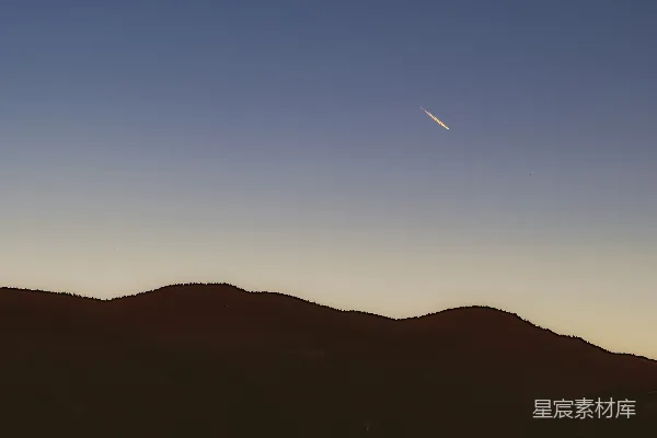 高清摄影 一道明亮的光带划过暗山上方的暮色天空。