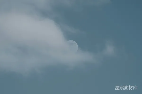 高清摄影 一架飞机在空中飞行，背景中有一弯新月。