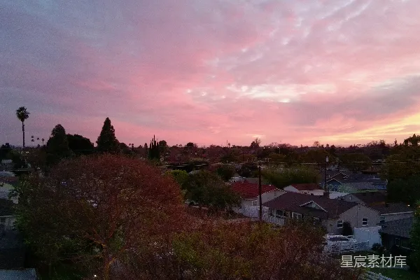 高清摄影 粉色和橙色的夕阳映照在郊区屋顶上。