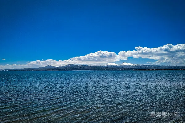高清摄影 一片宽阔的水域，背景是山脉。