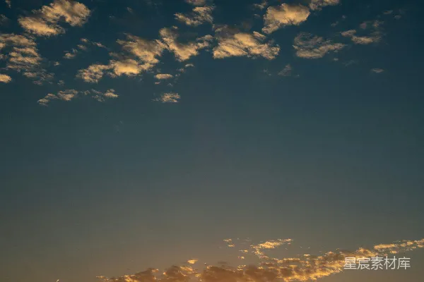 高清摄影 晴空一片湛蓝，夕阳余晖下，云彩零散分布。
