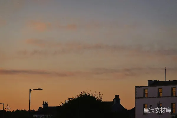 高清摄影 夕阳西下，映照着剪影中的建筑物和街灯。