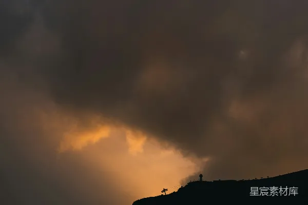 高清摄影 一个人站在山顶上，天空布满云彩。