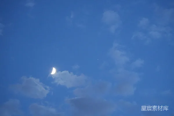 高清摄影 在蓝色的天空中，能看到一轮弯月。