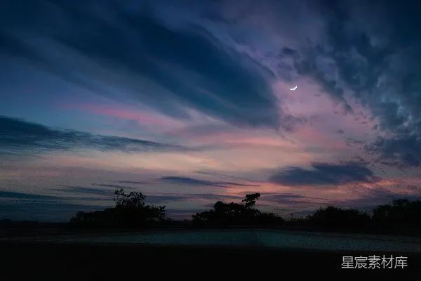 高清摄影 夜晚的天空，云层缭绕，远处有月亮。