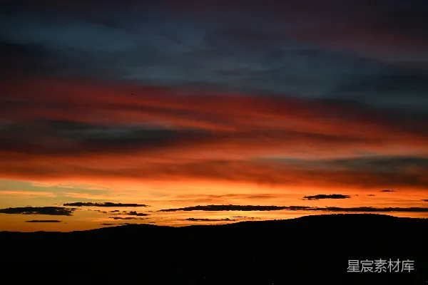高清摄影 色彩斑斓的夕阳天空，山脚下是轮廓分明的山峦。