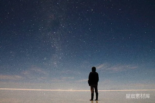 高清摄影 一个男人站在田野里，天空中有星星。