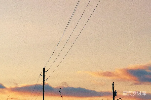 高清摄影 电线横跨在夕阳的粉彩天空之上。