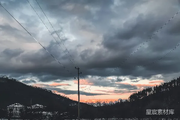 高清摄影 一座山上空云雾缭绕，前景中有一根电线杆。