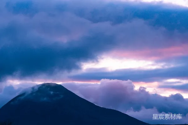 高清摄影 黑暗的山峰在变幻莫测、色彩斑斓的云层下。