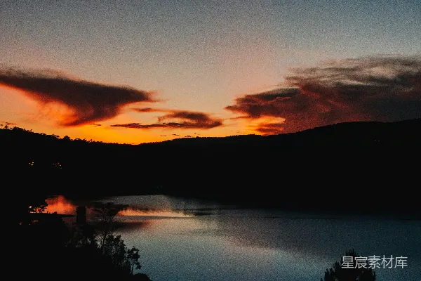高清摄影 一片有树木和夕阳背景的水域。