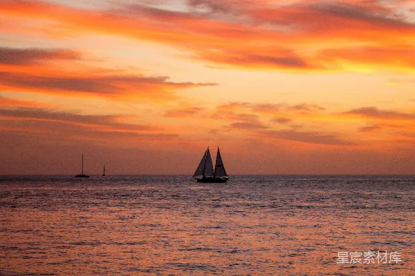 高清摄影 夕阳西下，帆船在大海中航行。