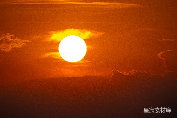 高清摄影 夕阳在橙色的天空中落下，云朵飘过。