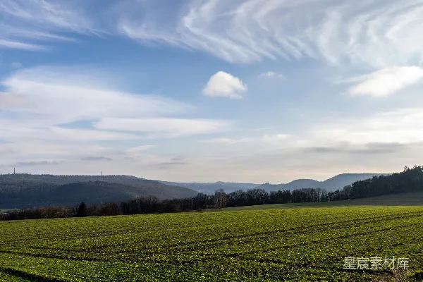 高清摄影 一片广阔的草地，背景是连绵的山脉。