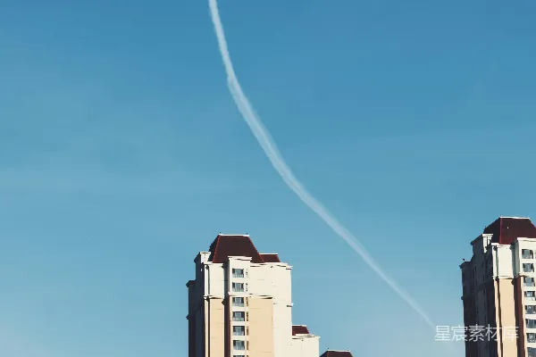 高清摄影 一架飞机在高大建筑物上方的天空中飞行。