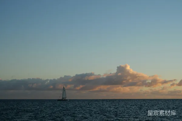 高清摄影 一艘帆船在多云的天空下漂浮在海洋中