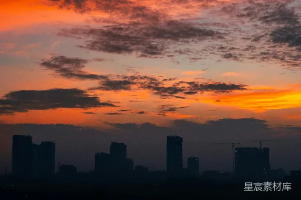 高清摄影 城市天际线在令人印象深刻的橙红色日落背景下剪影。
