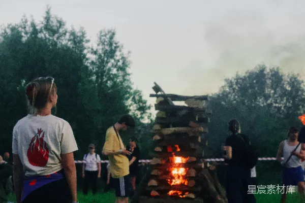 高清摄影 人们在草地上观看一场大型篝火。