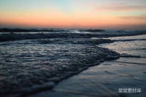 高清摄影 夕阳下，海浪轻拍着海岸。