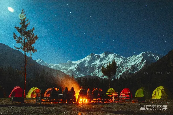 高清摄影 星空下的露营，有篝火、帐篷和雪山。
