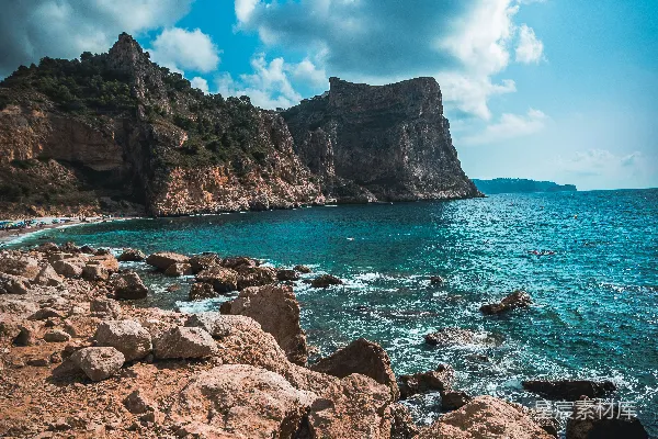 高清摄影 一个岩石海滩，背景中有一大片水域。
