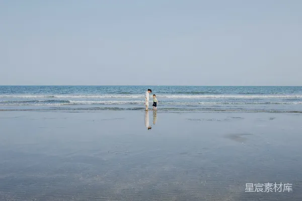 高清摄影 人们沿着海滩朝向大海走去。