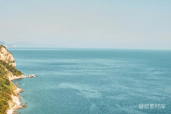 高清摄影 一片宽阔的水域坐落在郁郁葱葱的山坡旁边