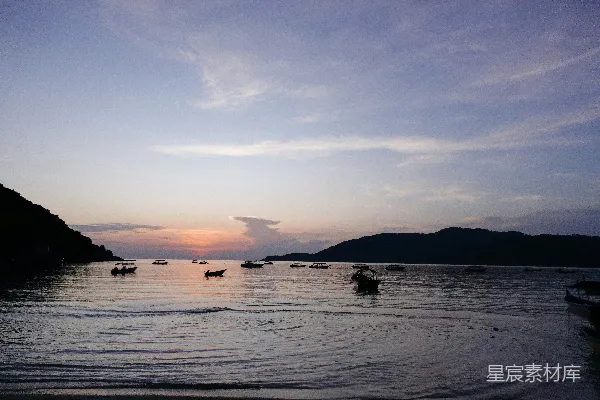 高清摄影 一片水域，里面停泊着船只，背景是山脉。