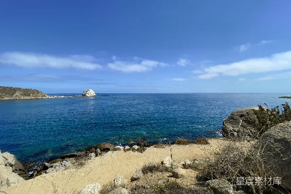 高清摄影 岩石海滩，背景是一片水域。